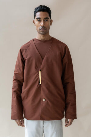 Man in brown shirt posing for fashion shoot.