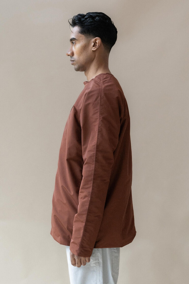 Man in brown long sleeve shirt, profile view.