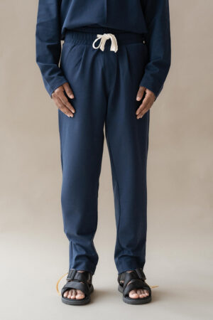 Person modeling navy tracksuit and black sandals.