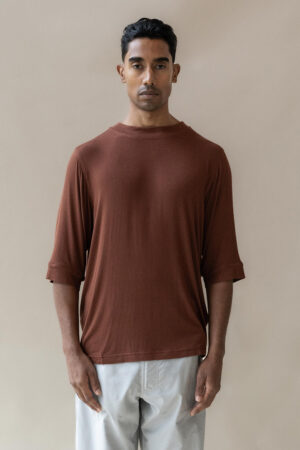 Man in brown t-shirt and white trousers.